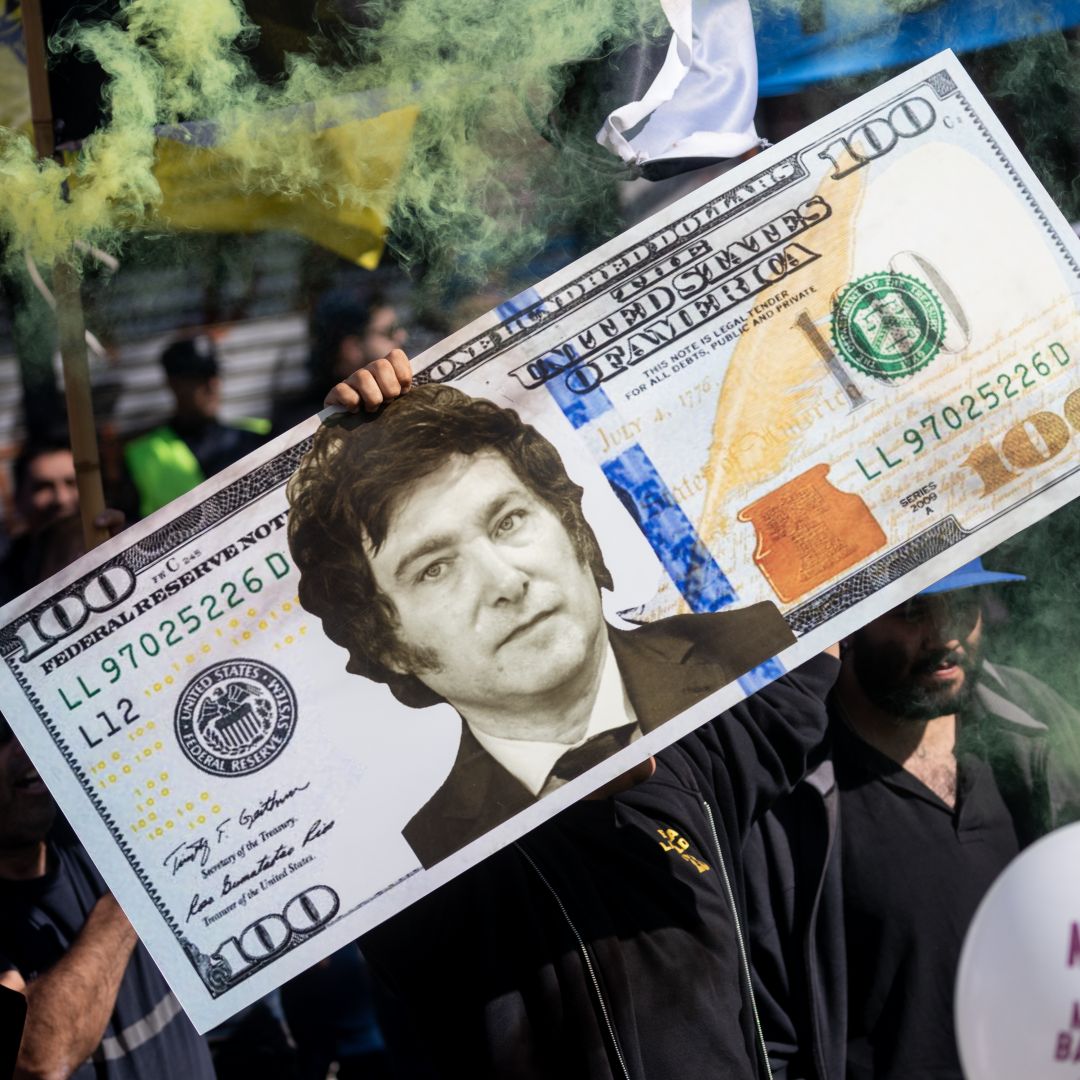 A supporter of Argentine presidential candidate Javier Milei, who has pledged to dollarize the country's economy, holds up a gigant fake U.S. dollar bill with Milei's face on it during a rally in Buenos Aires on Sept. 25, 2023. 