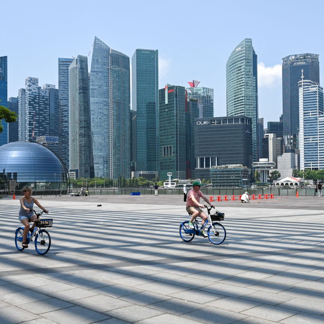 People cycle along the promenade at Marina Bay in Singapore on Oct. 13, 2023. 
