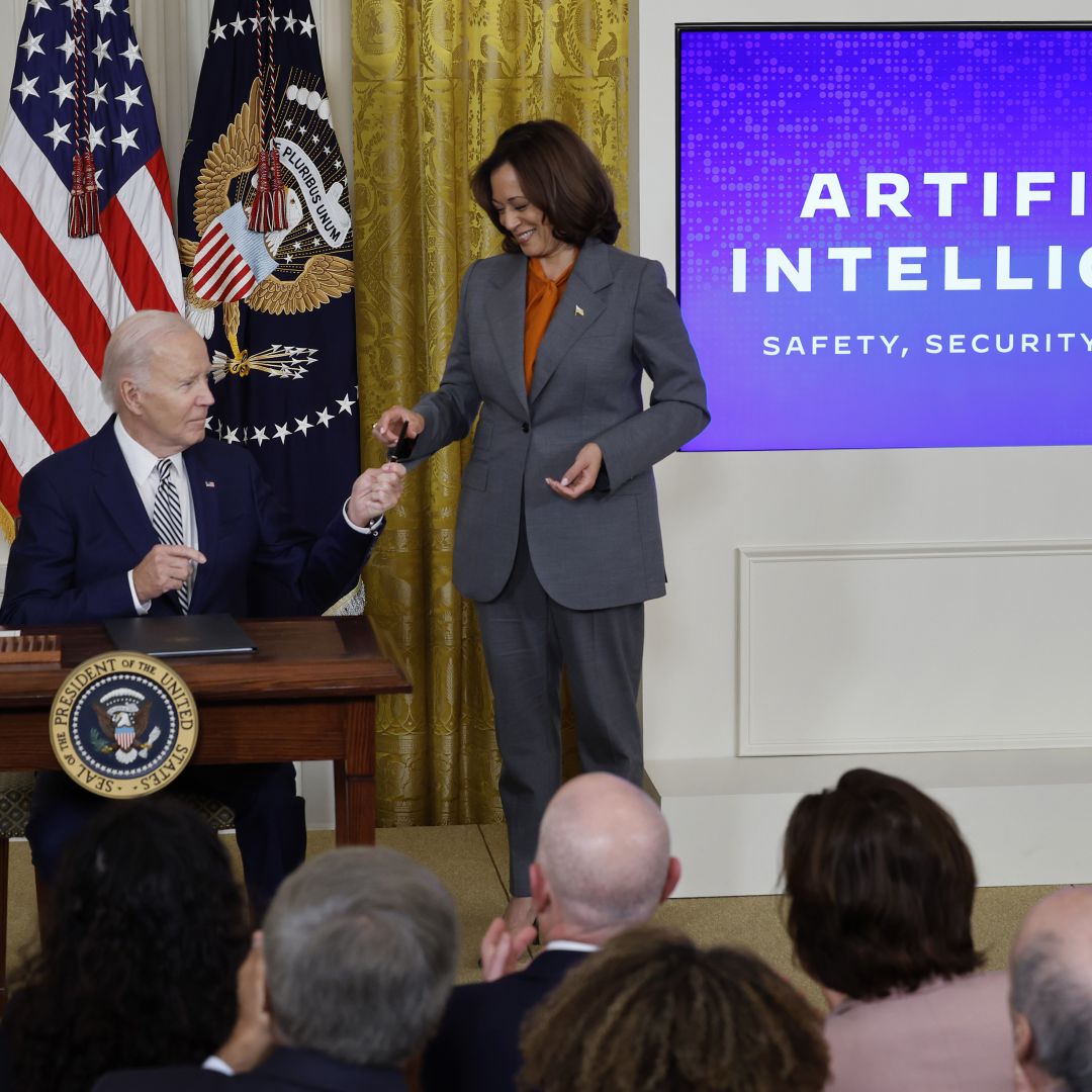 U.S. President Joe Biden hands Vice President Kamala Harris his pen after signing a new AI executive order in the East Room of the White House on Oct. 30, 2023.  