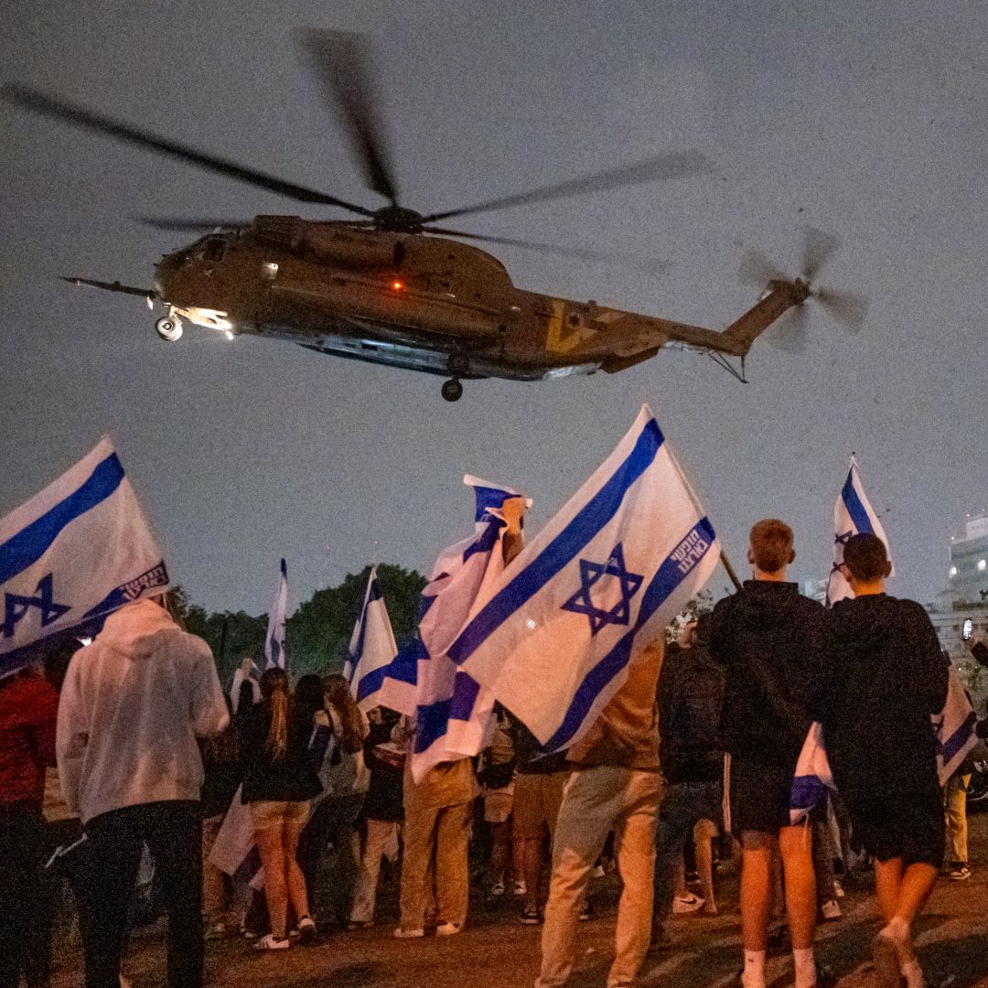 People wave flags and cheer as a helicopter with Israeli hostages released earlier by Hamas lands at a medical center on Nov. 26, 2023, in Petah Tikva, Israel. People wave flags and cheer as a helicopter with Israeli hostages released earlier by Hamas lands at a medical center on Nov. 26, 2023, in Petah Tikva, Israel.