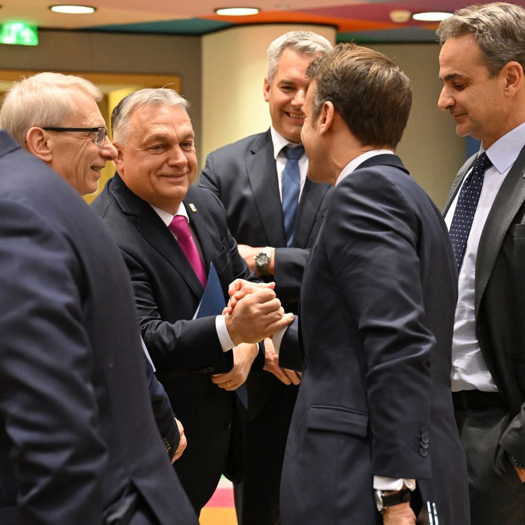 Hungarian Prime Minister Viktor Orban (center left) and French President Emmanuel Macron (center right) shake hands ahead of an EU summit in Brussels, Belgium, on Dec. 14, 2023. 