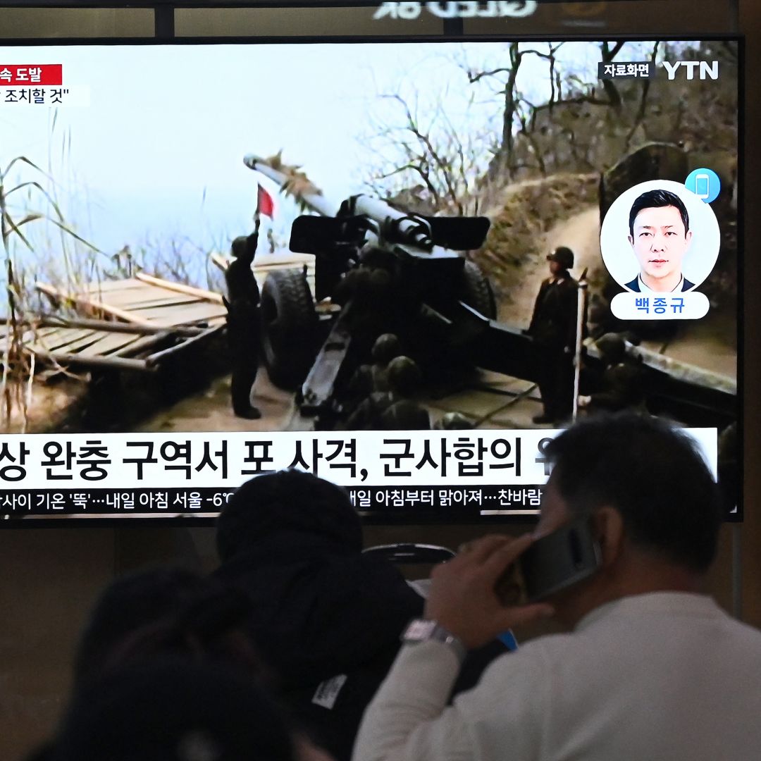 People watch a television screen showing a news broadcast with file footage of North Korea's artillery firing, at a railway station in Seoul on Jan. 6, 2024.