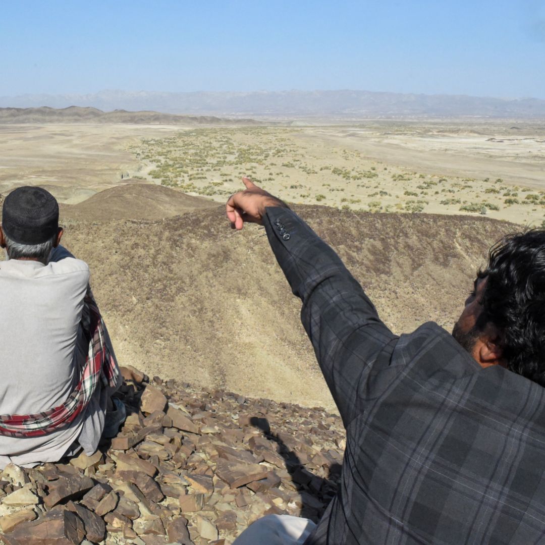A photo taken on Jan. 18, 2024, shows a resident pointing to a mountain in the Koh-e-Sabz area of Pakistan's southwest Balochistan province where Iran recently launched an airstrike.