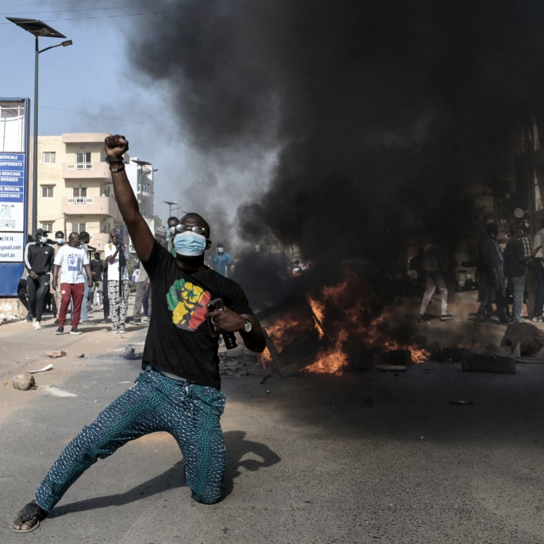 An opposition supporter reacts in front of a burning barricade during demonstrations in Dakar, Senegal, on Feb. 4, 2024, after President Macky Sall announced the postponement of the presidential election. 