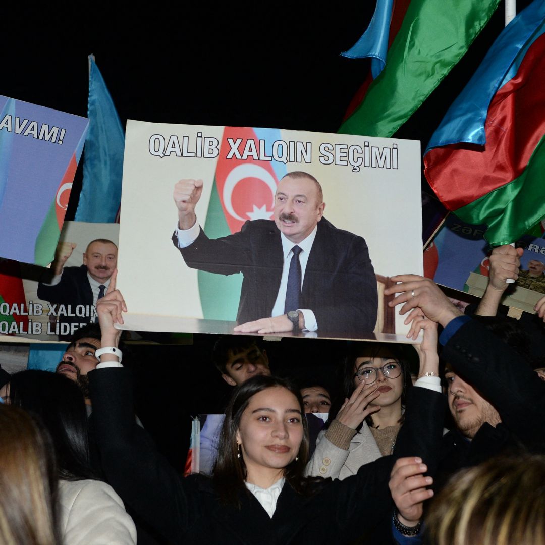 Supporters of Azerbaijani President Ilham Aliyev rally with national flags and his portraits in Baku, Azerbaijan, after polls closed in the country's snap presidential election on Feb. 7, 2024. 