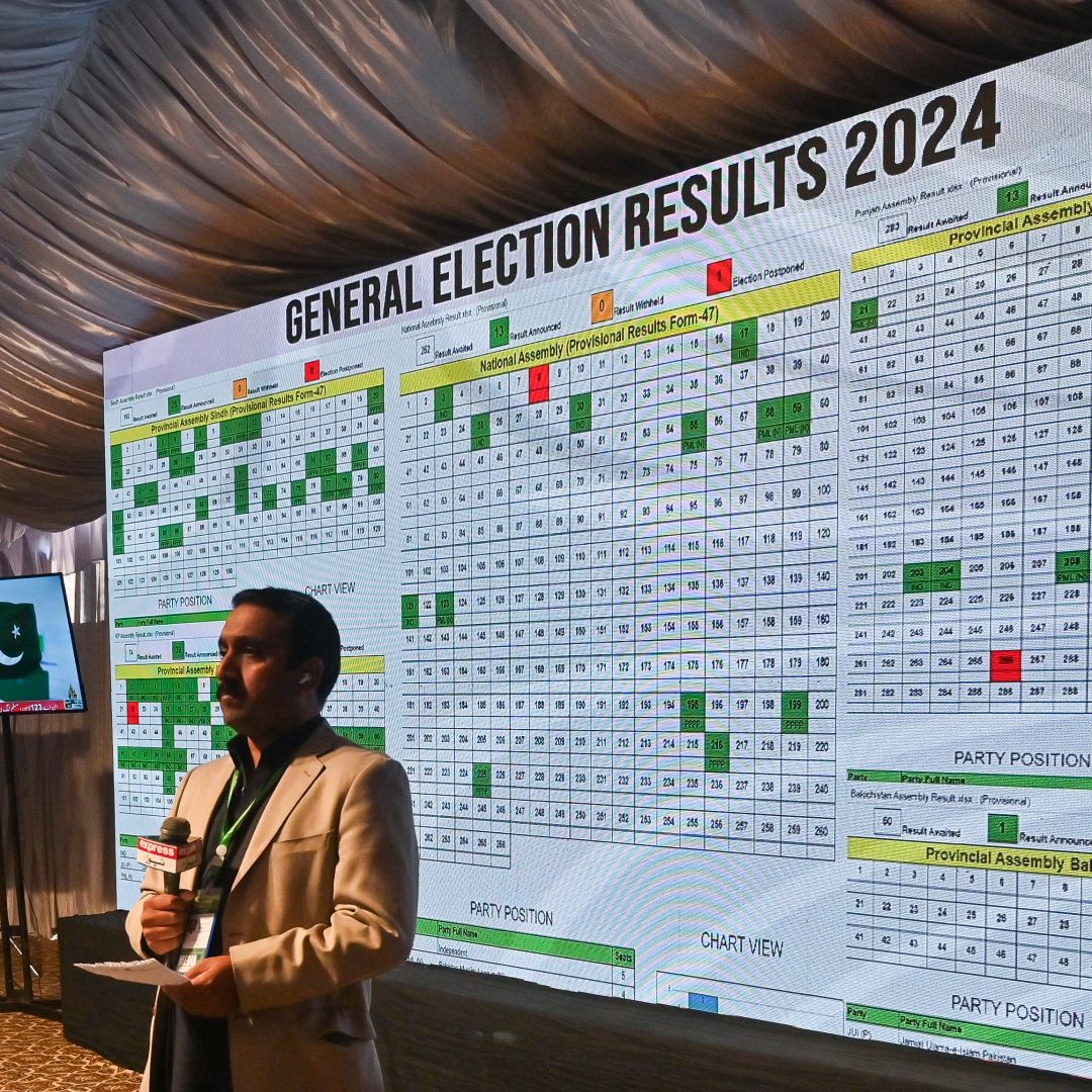 A journalist stands in front of a screen displaying live election results during a televised broadcast in Islamabad, Pakistan, on Feb. 9, 2024, a day after national elections were held in the country.