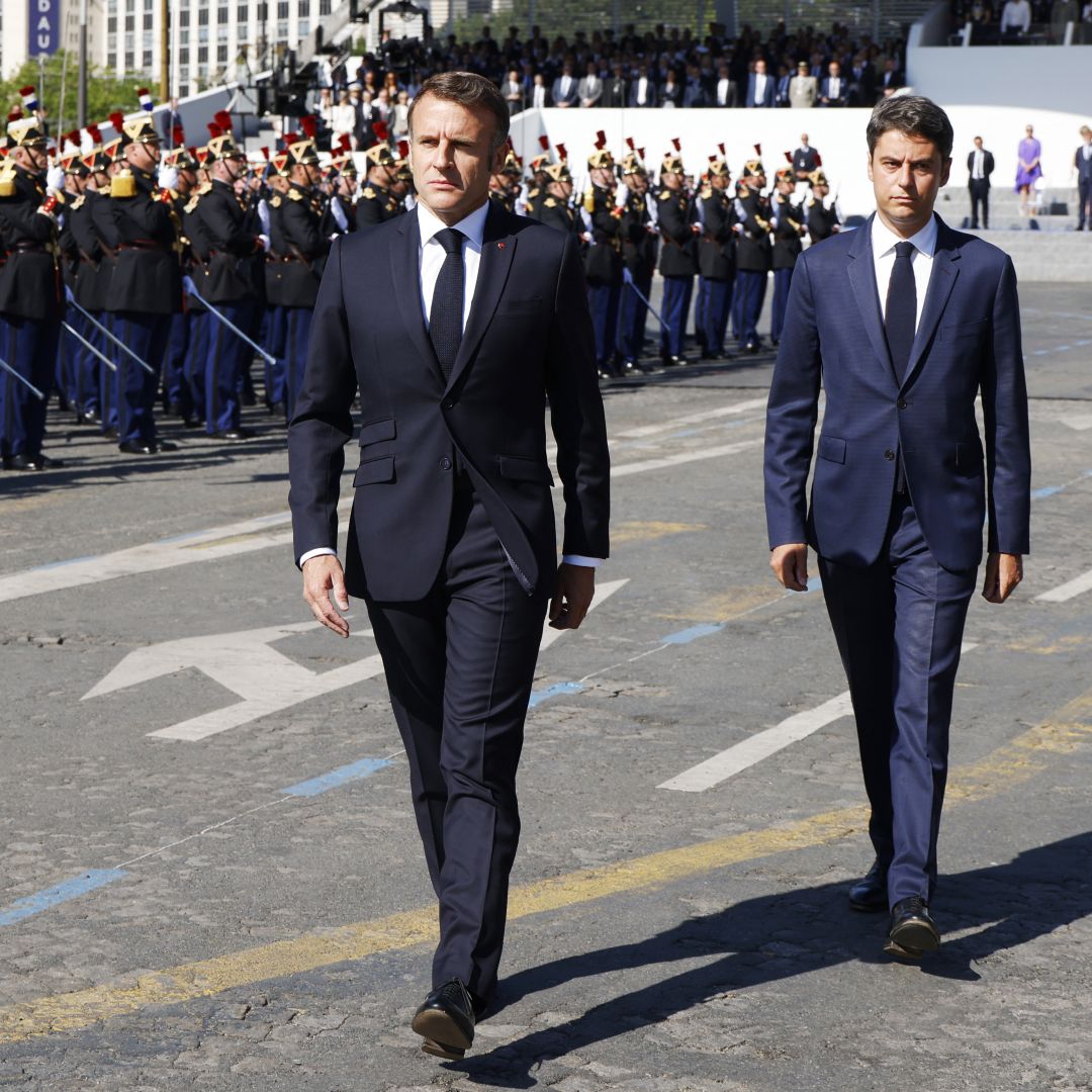 French President Emmanuel Macron (center, in foreground) and French Prime Minister Gabriel Attal review the troops during the Bastille Day military parade in Paris, France, on July 14, 2024.