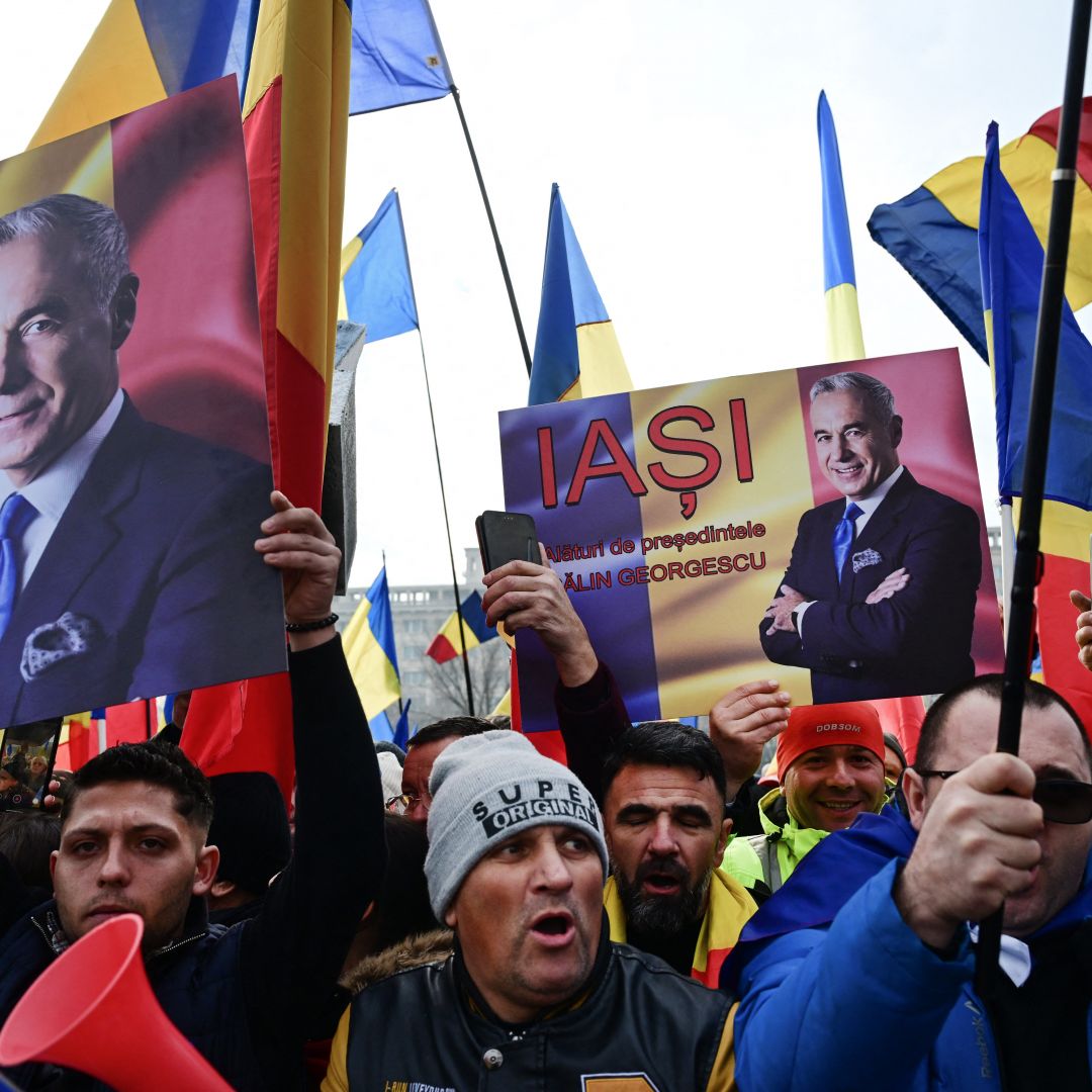 People wave Romanian flags and hold portraits of far-right presidential candidate Calin Georgescu during a protest in front of Romania's Constitutional Court in Bucharest on Jan. 10, 2025. 