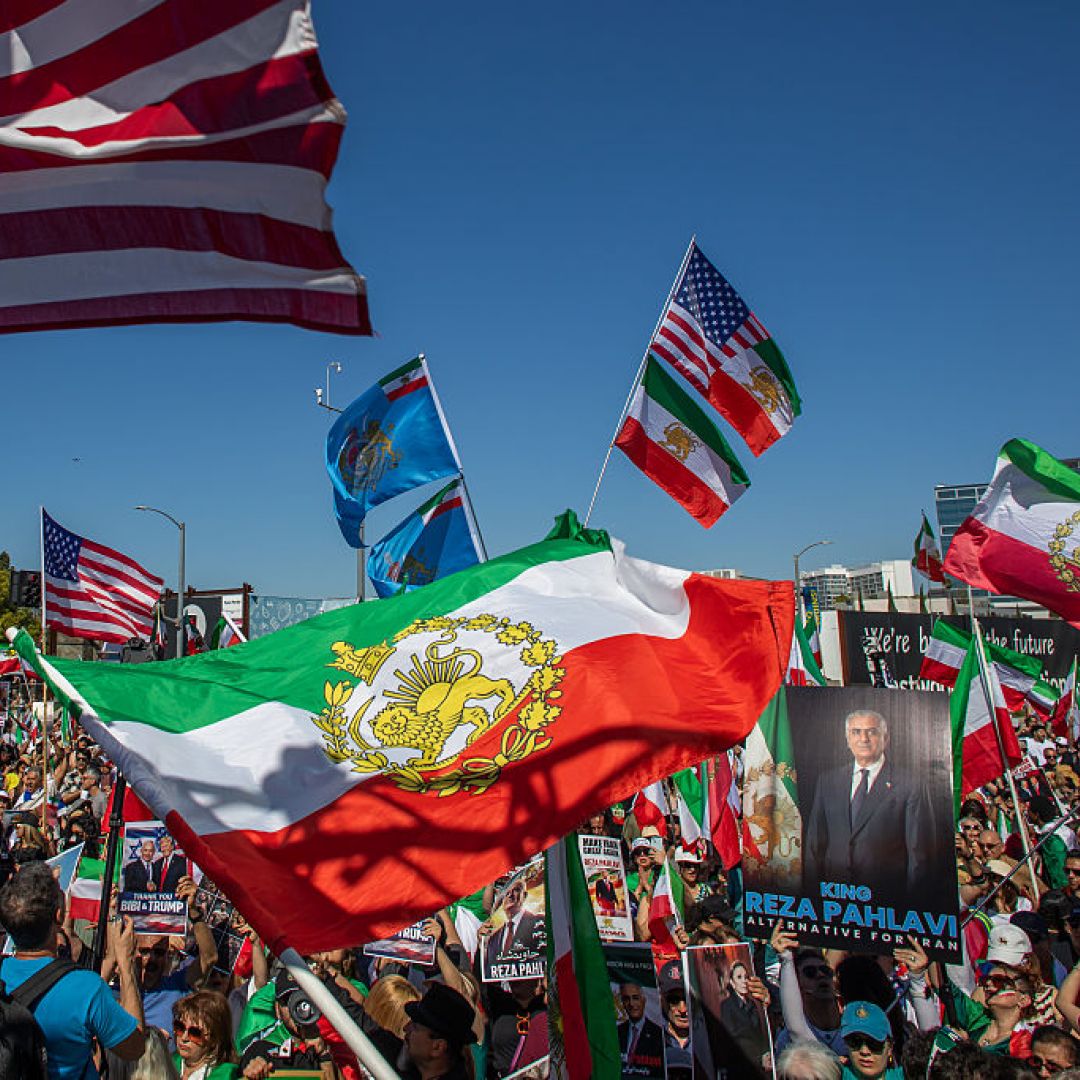 People wave Iranian pre-1979 Islamic Revolution and American flags while members of the Iranian community celebrate in front of the Federal Building on March 1, in Los Angeles. 