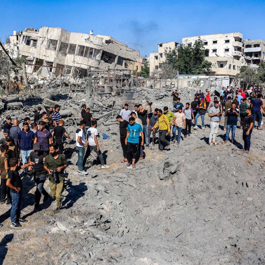 People gather by the rubble of destroyed buildings following an Israeli strike on an industrial area in Gaza City on July 12.