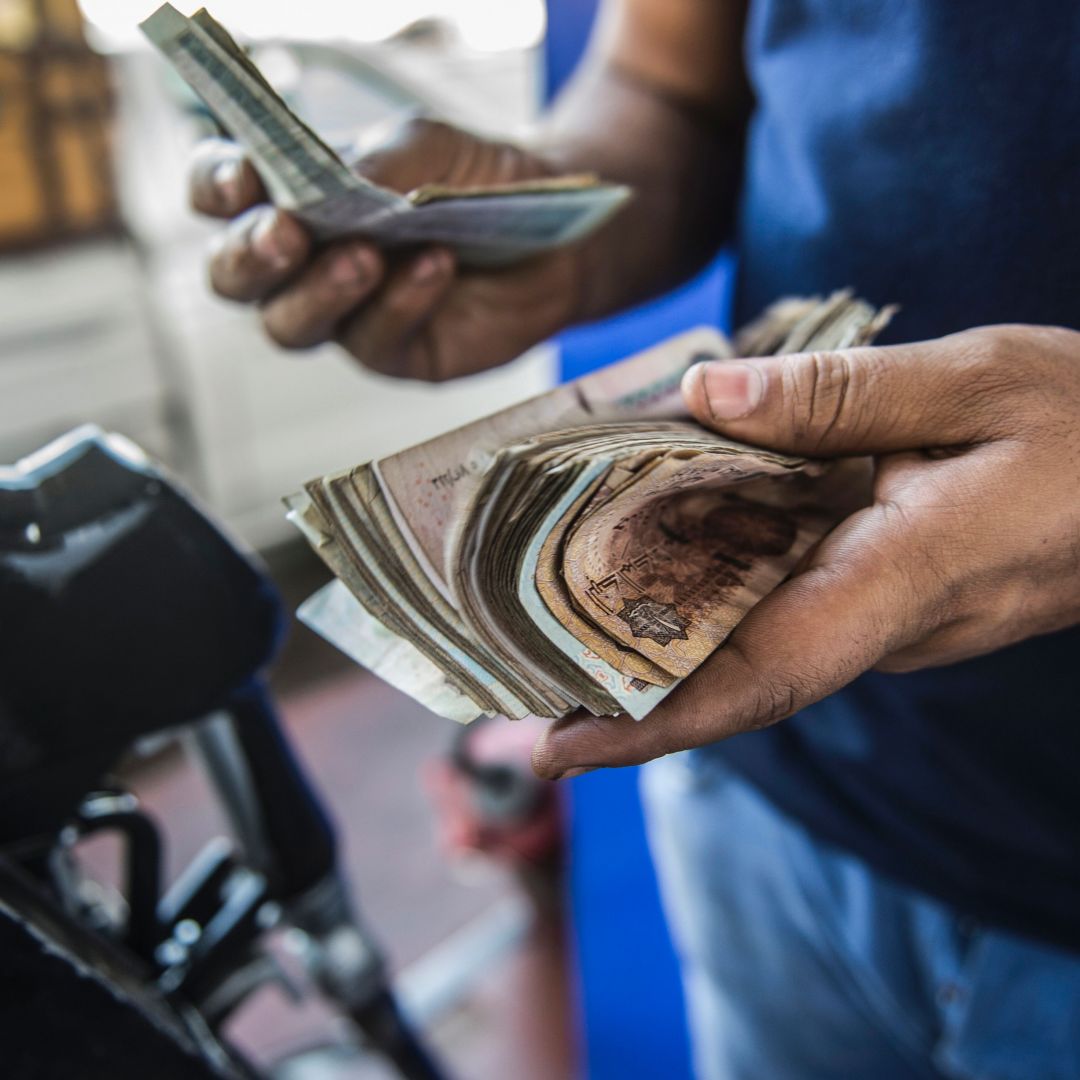 A gas station worker counts cash collected from customers in Cairo on June 29, 2017, after Egypt’s government slashed fuel subsidies. 