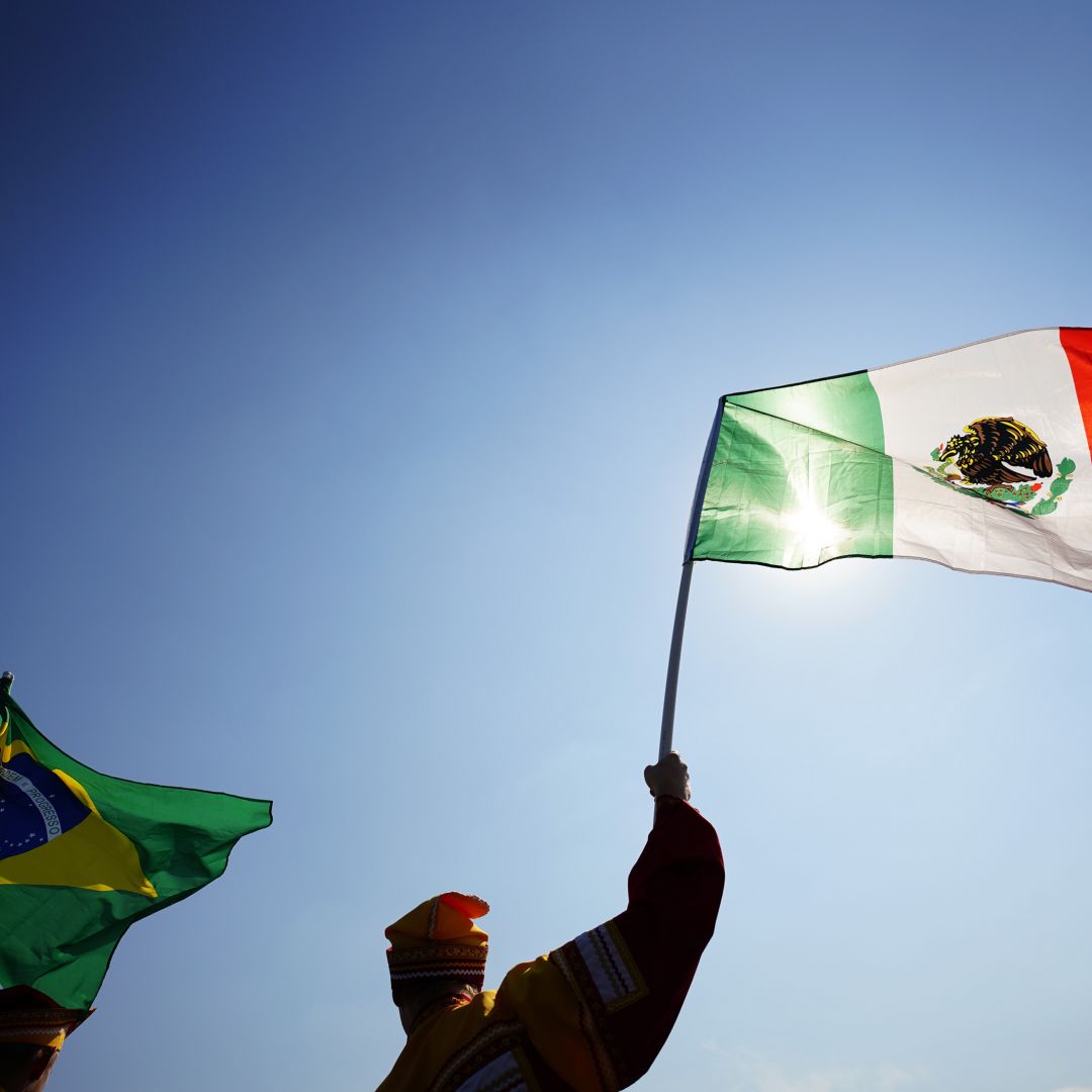 Fans hold up Mexico and Brazil's national flags at the 2018 FIFA World Cup.