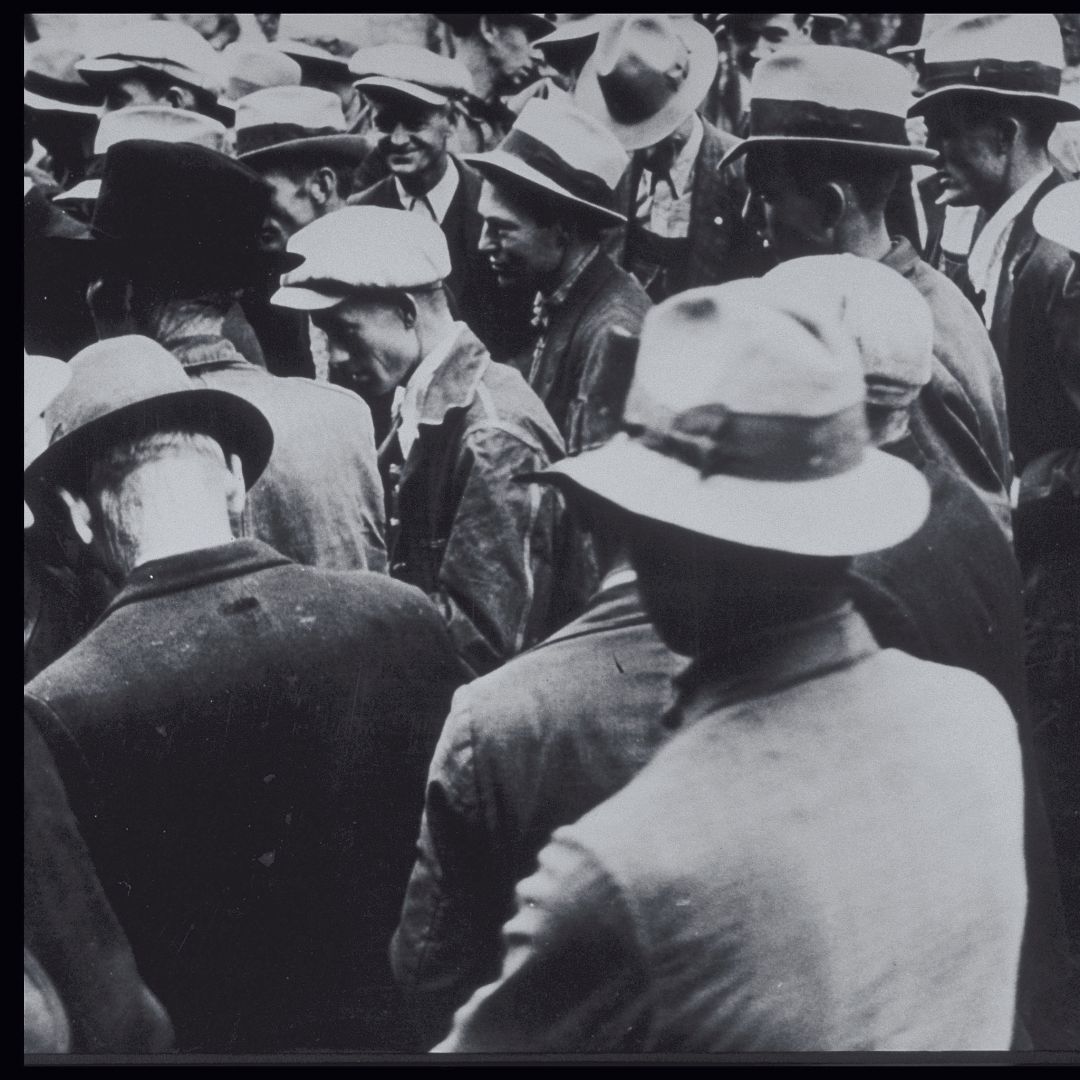 A crowd of men in 1930 wearing jackets and hats. A crowd of men in 1930 wearing jackets and hats.