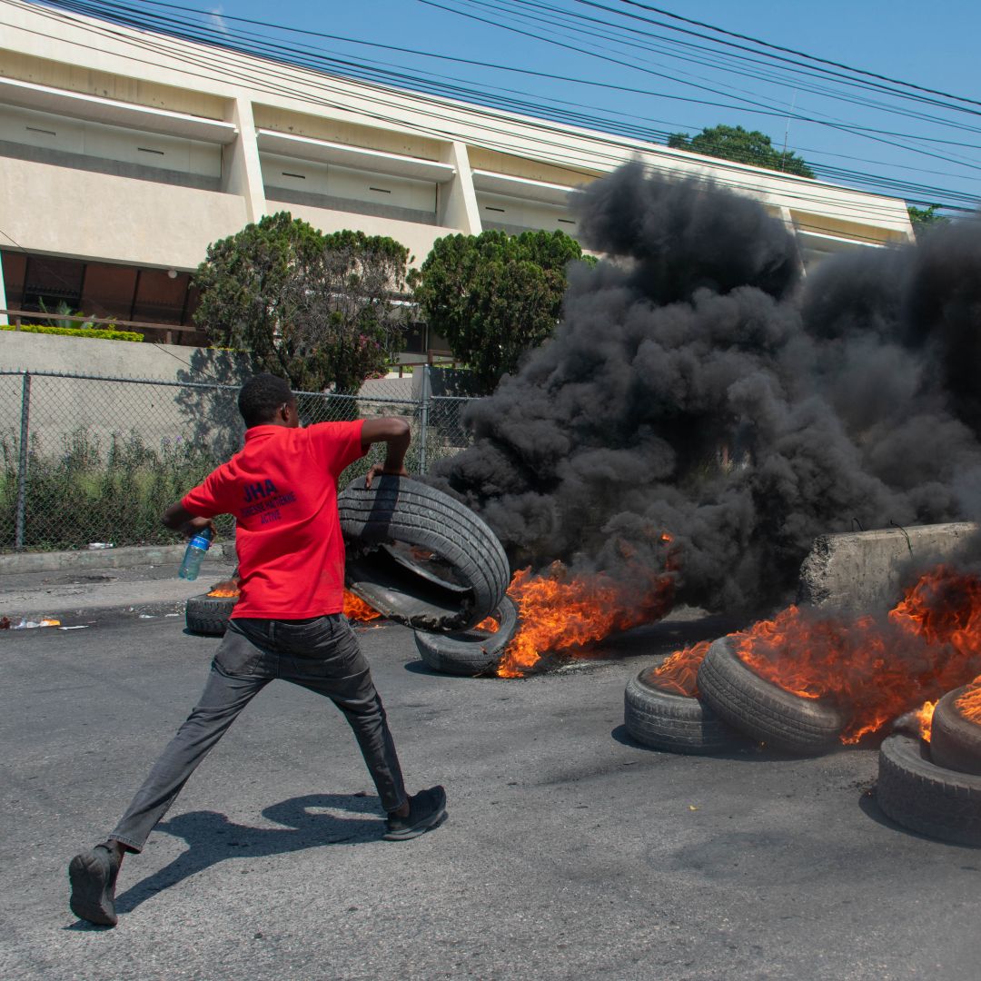 A protester burns tires during a demonstration in Port-au-Prince, Haiti, on March 12, 2024, after Haitian Prime Minister Ariel Henry announced his plans to resign. 