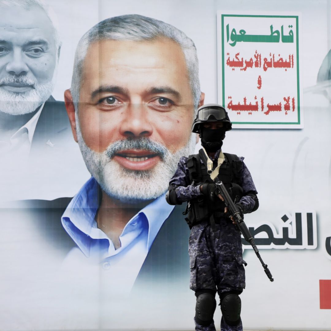 A security guard stands in front of a poster of Hamas' slain political leader, Ismail Haniyeh, on Aug. 2, 2024, in Sanaa, Yemen.