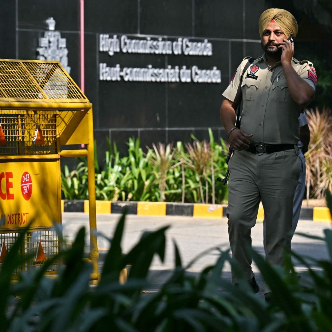 Indian policemen stand guard outside the entrance of the High Commission of Canada in New Delhi on Oct. 15, 2024. 