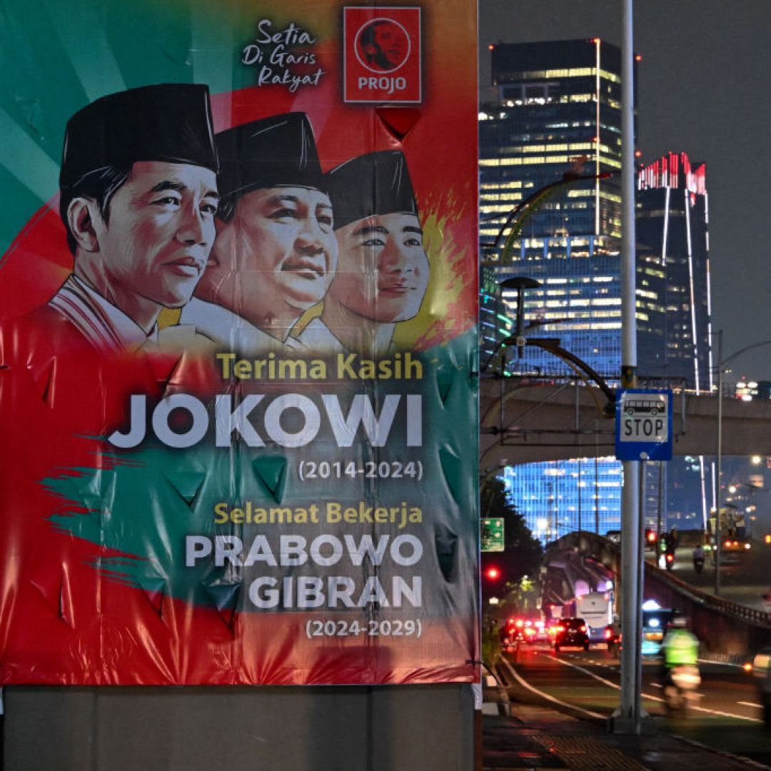 Vehicles pass by a banner thanking outgoing Indonesian President Joko "Jokowi" Widodo and congratulating President-elect Prabowo Subianto and Vice President-elect Gibran Rakabuming Raka ahead of their Oct. 20 inauguration in Jakarta, Indonesia, on Oct. 17, 2024.