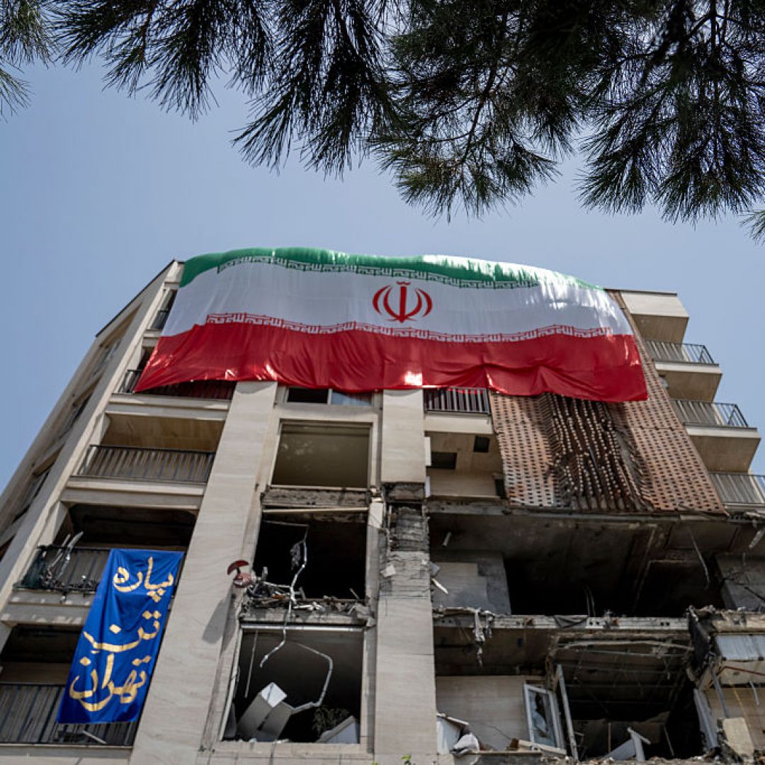 An Iranian flag is draped from a building damaged during a recent attack by Israel is seen in the Gisha neighborhood of Tehran, Iran, on June 25, 2025. 