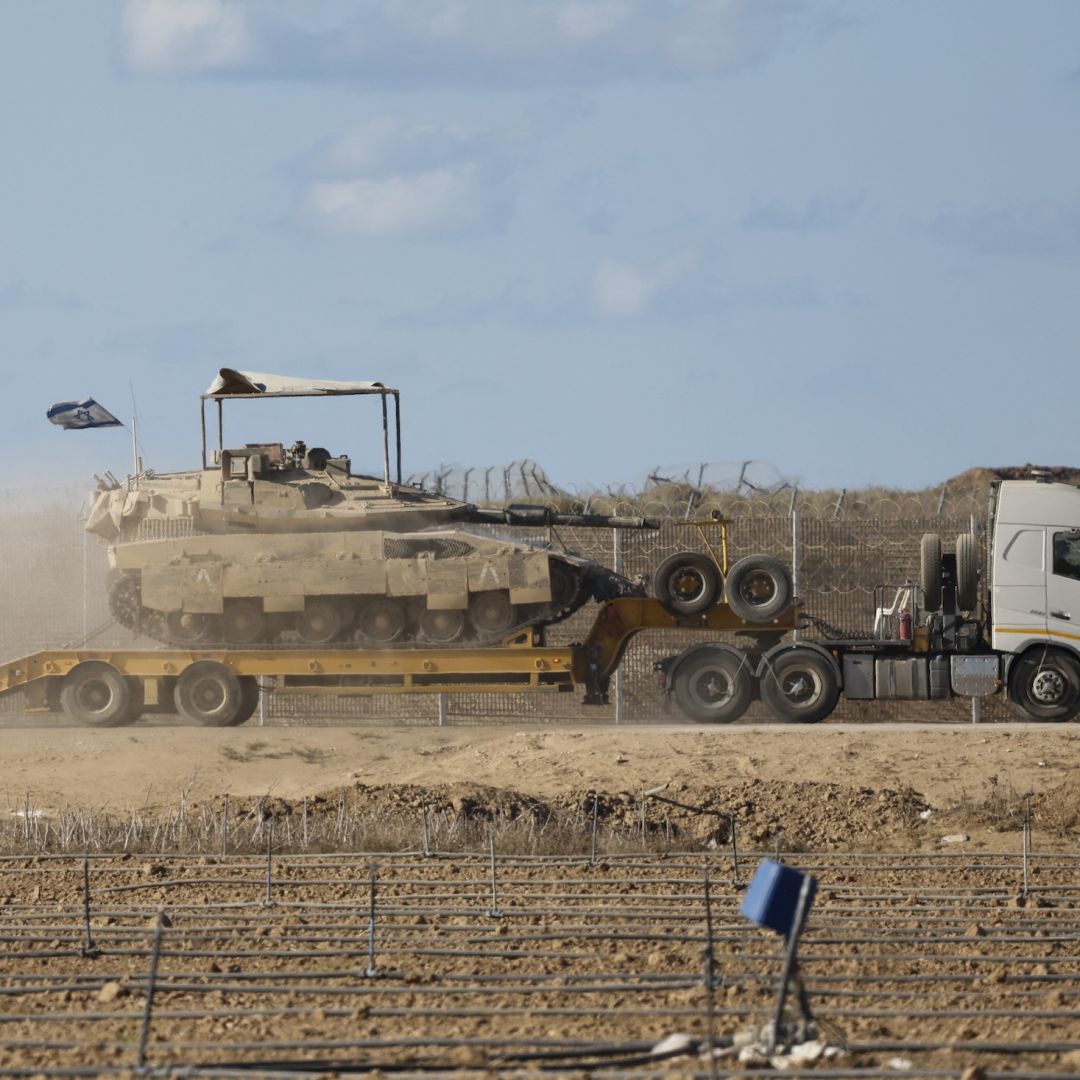 An Israeli military truck carries a tank in southern Israel on the border with the Gaza Strip, on Oct. 14, 2025.