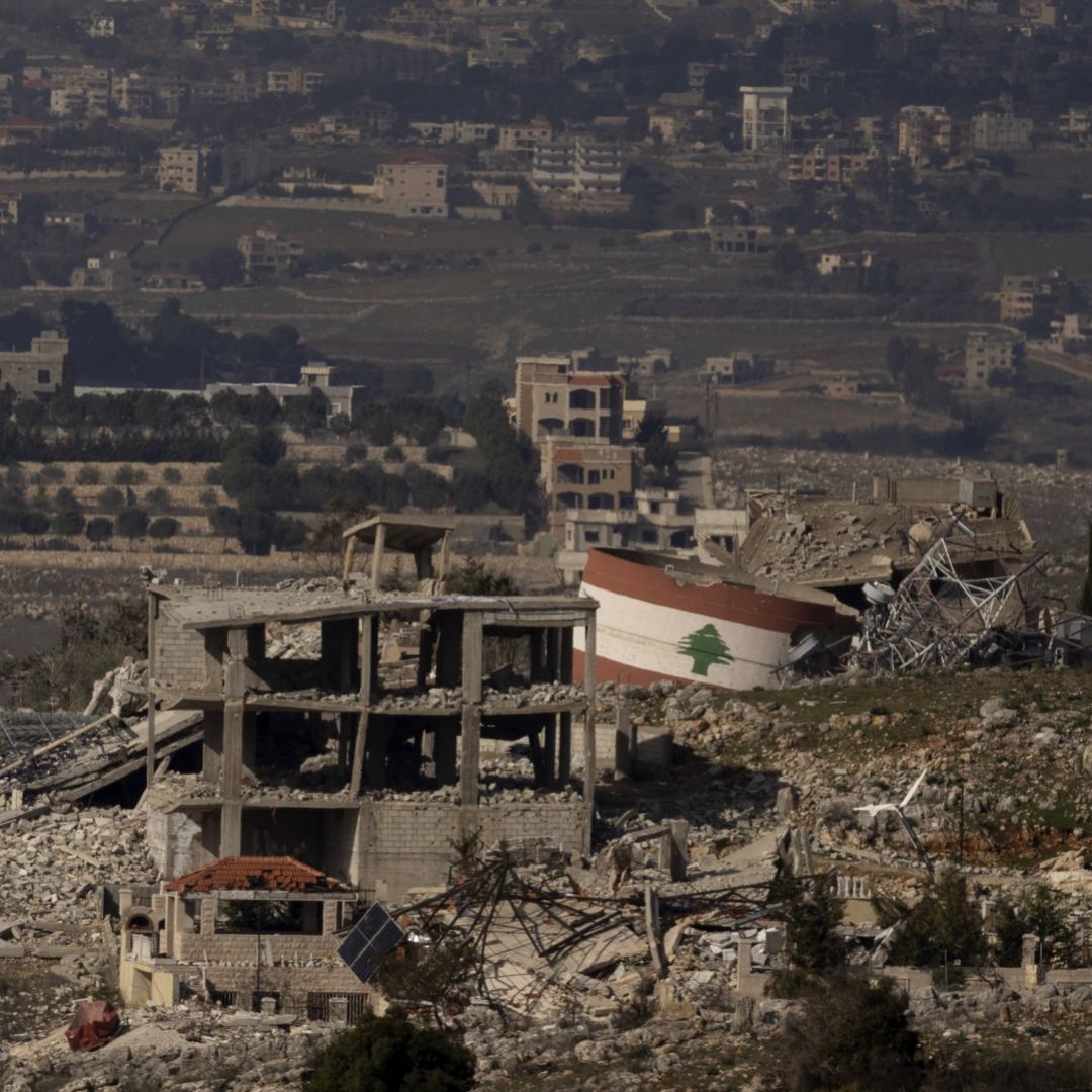 A Lebanese flag painted on a damaged building in a village in southern Lebanon is seen from a position on the Israeli side of the border on Jan. 23, 2025. 