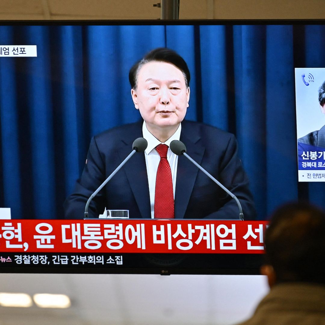 South Korean President Yoon Suk Yeol speaks during a news broadcast on a television at a train station in Seoul on Dec. 3, 2024, after Yoon declared emergency martial law.