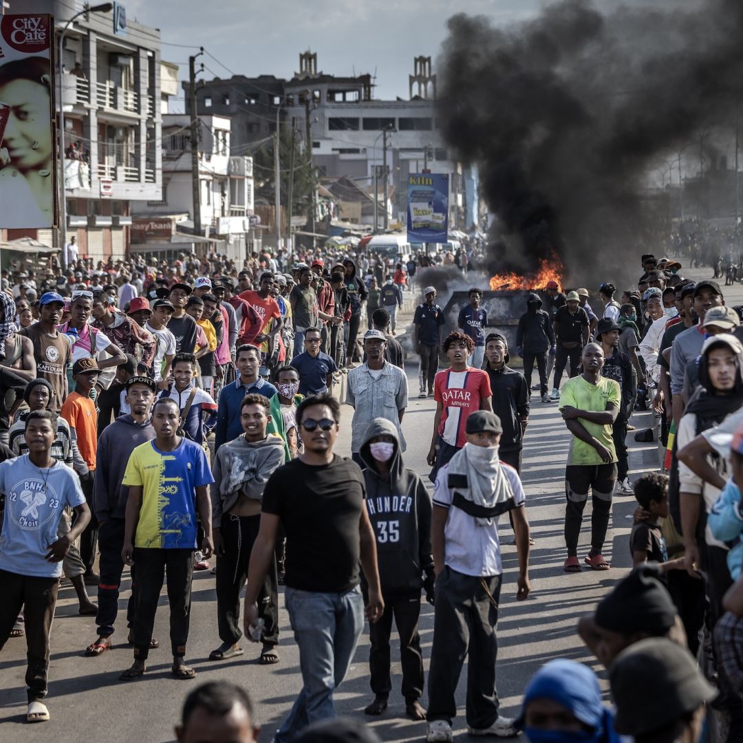Protesters face police from a distance near burning barricades in Antananarivo, Madagascar, on Oct. 9, 2025. 
