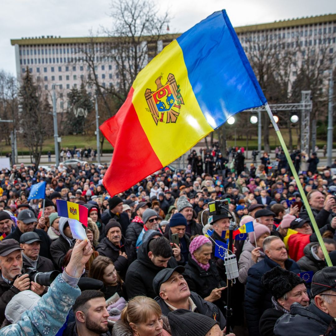 People hold Moldovan national flags as they gather outside the presidential palace in Chisinau on Dec. 14, 2023, to celebrate the European Council's decision to open accession talks with Moldova.
