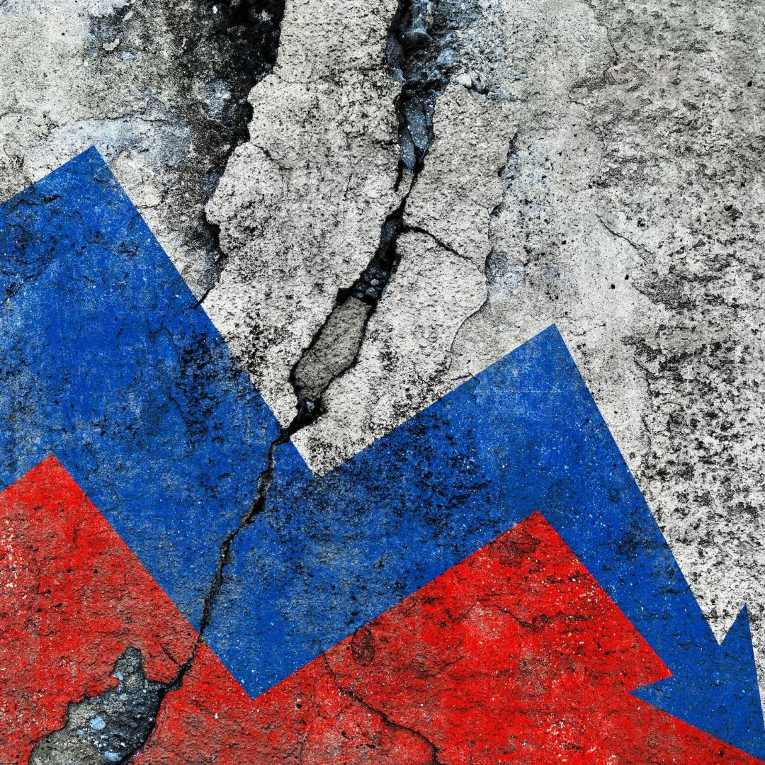 Russian flag on a cracked wall, illustrating an economic decline with a downward arrow. 