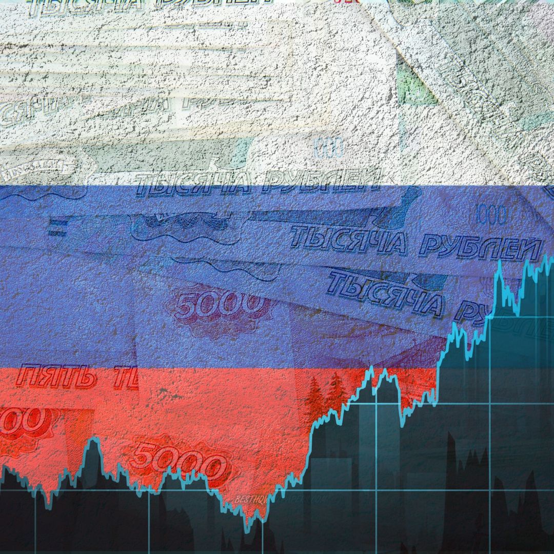 A graph of the ruble exchange rate against the background of the Russian flag and paper banknotes. 