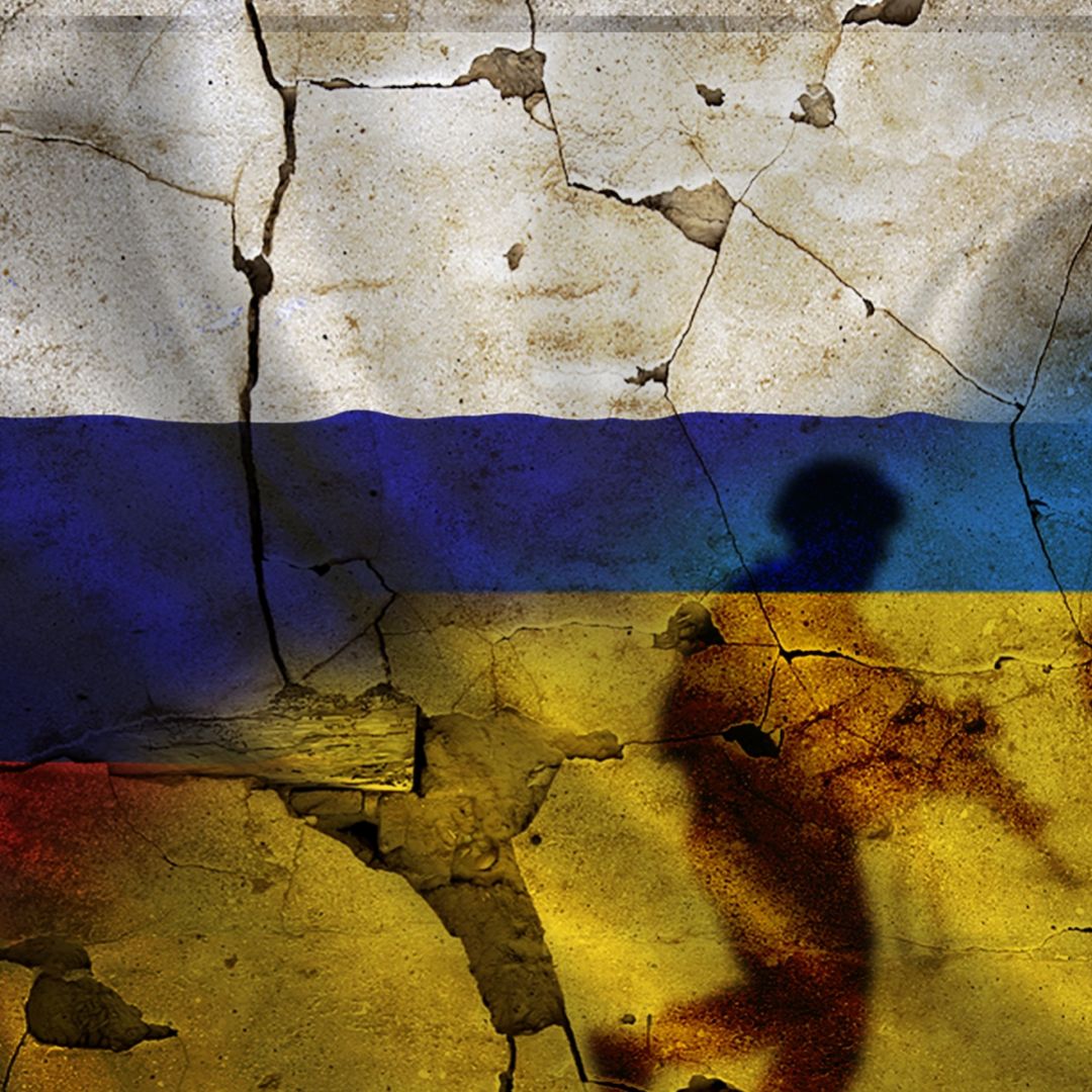 Russia and Ukraine flags on a cracked wall with the silhouettes of soldiers.