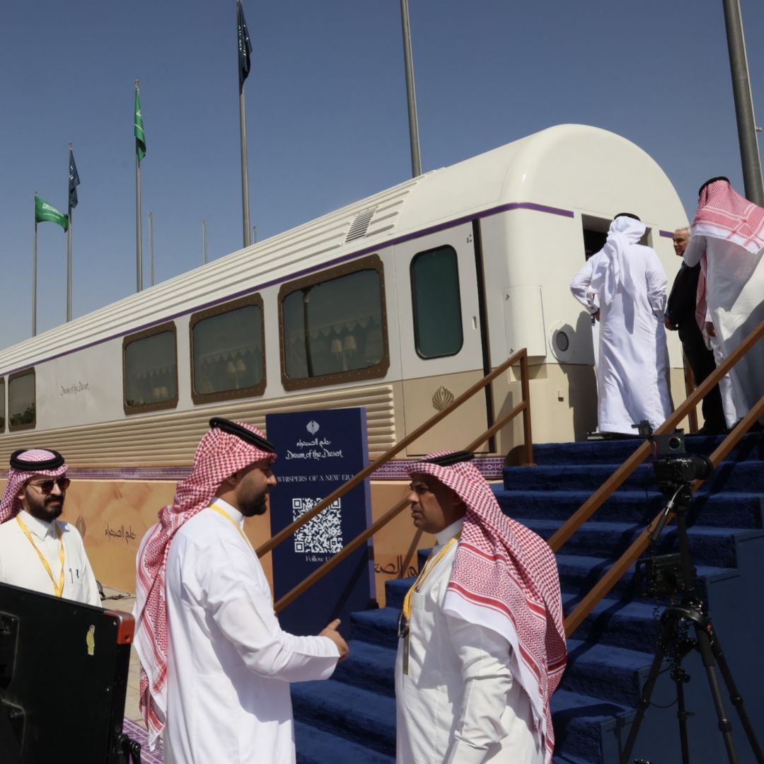 Guests stand outside a model carriage of the "Dream of the Desert" ultra-luxury train on display during the Future Investment Initiative conference in Riyadh, Saudi Arabia, on Oct. 28, 2025.