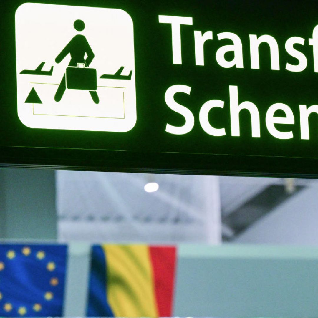 A newly installed sign pointing to Schengen transfer flights is pictured next to EU and Romanian flags on March 31, 2024. A newly installed sign pointing to Schengen transfer flights is pictured next to EU and Romanian flags on March 31, 2024.