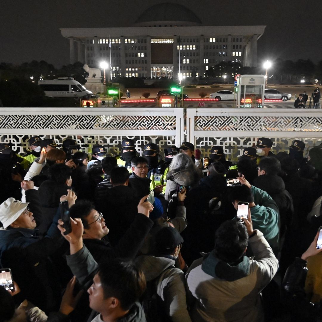 People gather in front of the main gate of the National Assembly in Seoul, South Korea on Dec. 4, 2024, after President Yoon Suk Yeol declared emergency martial law. 