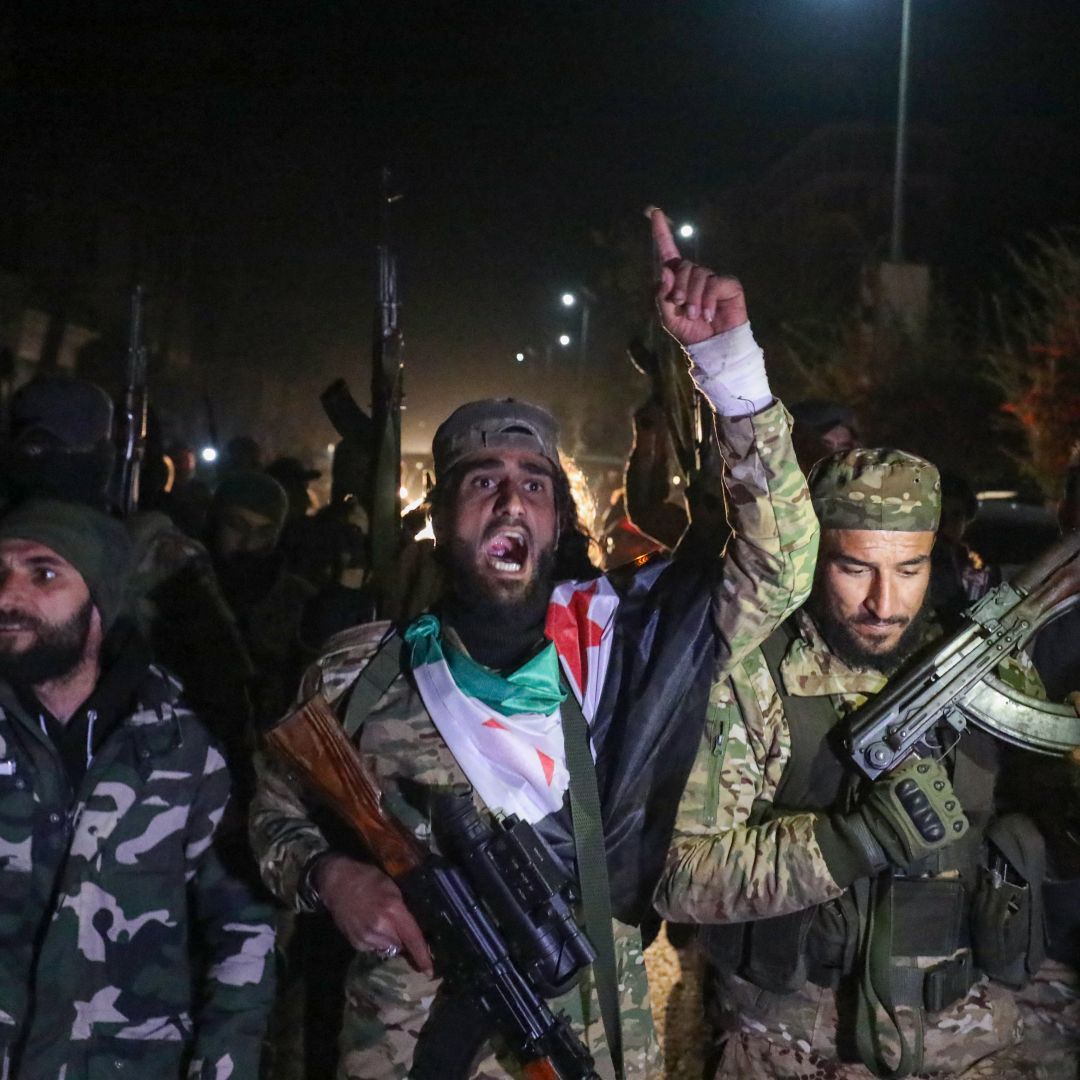 Rebel fighters celebrate in the streets of Homs, Syria, in the early hours of Dec. 8, 2024, after seizing control of the city.