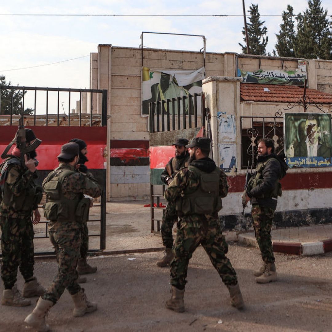 Fighters gather outside a building that was seized by jihadists in Syria's northern Aleppo province on Nov. 29, 2024, amid the Hayat Tahrir al-Sham (HTS) offensive against government forces. Fighters gather outside a building that was seized by jihadists in Syria's northern Aleppo province on Nov. 29, 2024, amid the Hayat Tahrir al-Sham (HTS) offensive against government forces.