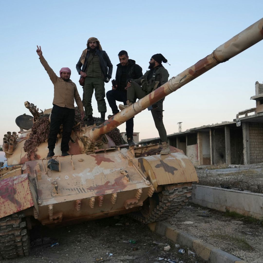 Rebel fighters pose for a picture on a tank on a road leading to Syria's northwestern Idlib province on Nov. 30, 2024. 