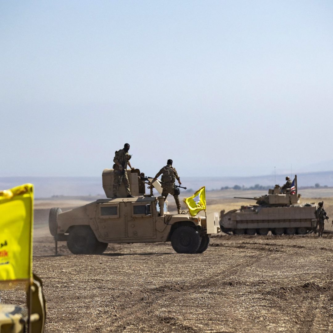 Fighters of the Syrian Democratic Forces (SDF) stand atop a humvee in Syria's northeastern Hasakah province during a joint military exercise with the U.S.-led coalition against the Islamic State on Sept. 7, 2022.