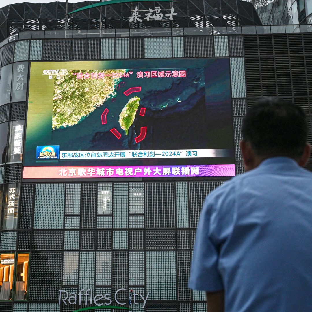 An outdoor screen shows news coverage of China's military drills around Taiwan, in Beijing, China, on May 23, 2024. 