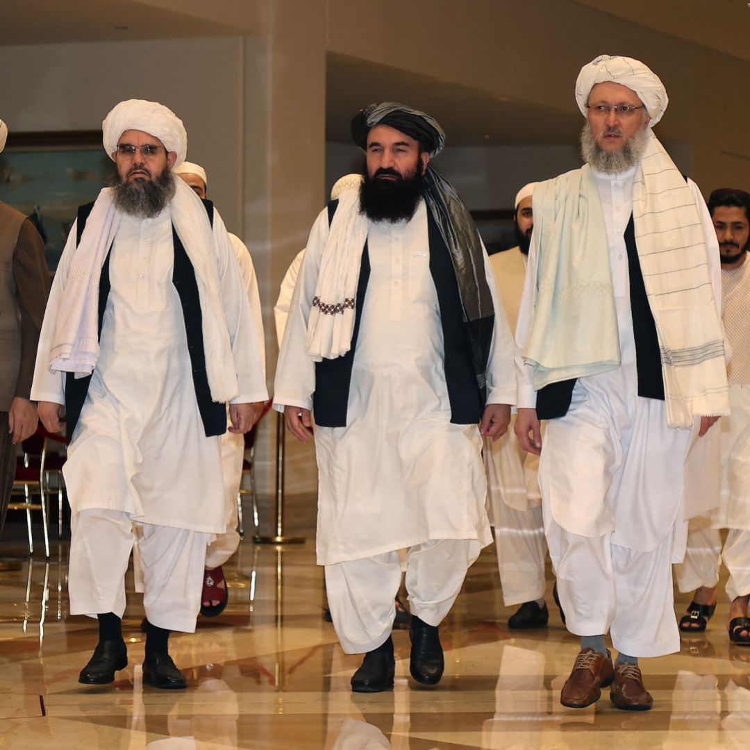 A delegation of Afghan Taliban officials walks down a hotel lobby in Doha, Qatar, in August 2021. 