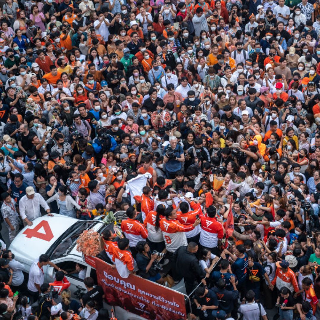A car with members of Thailand's opposition Move Forward Party (MFP), including leader Pita Limjaroenrat, drives through a large crowd of supporters during a rally in Bangkok on May 15, 2023, following the MFP's victory in the general election. 