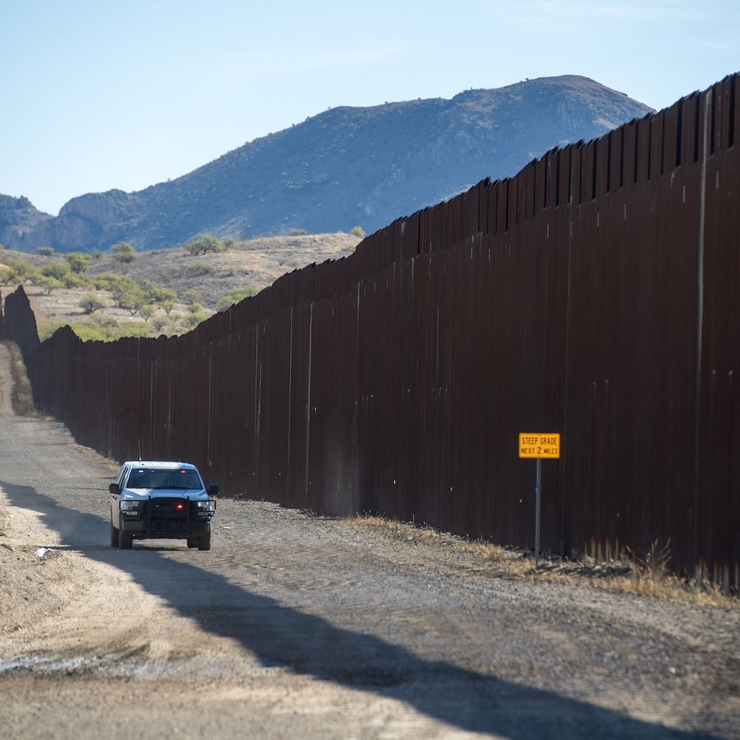 U.S. border patrol officials drive near the wall along the Mexican border in Sasabe, Arizona, on Dec. 8, 2023. 