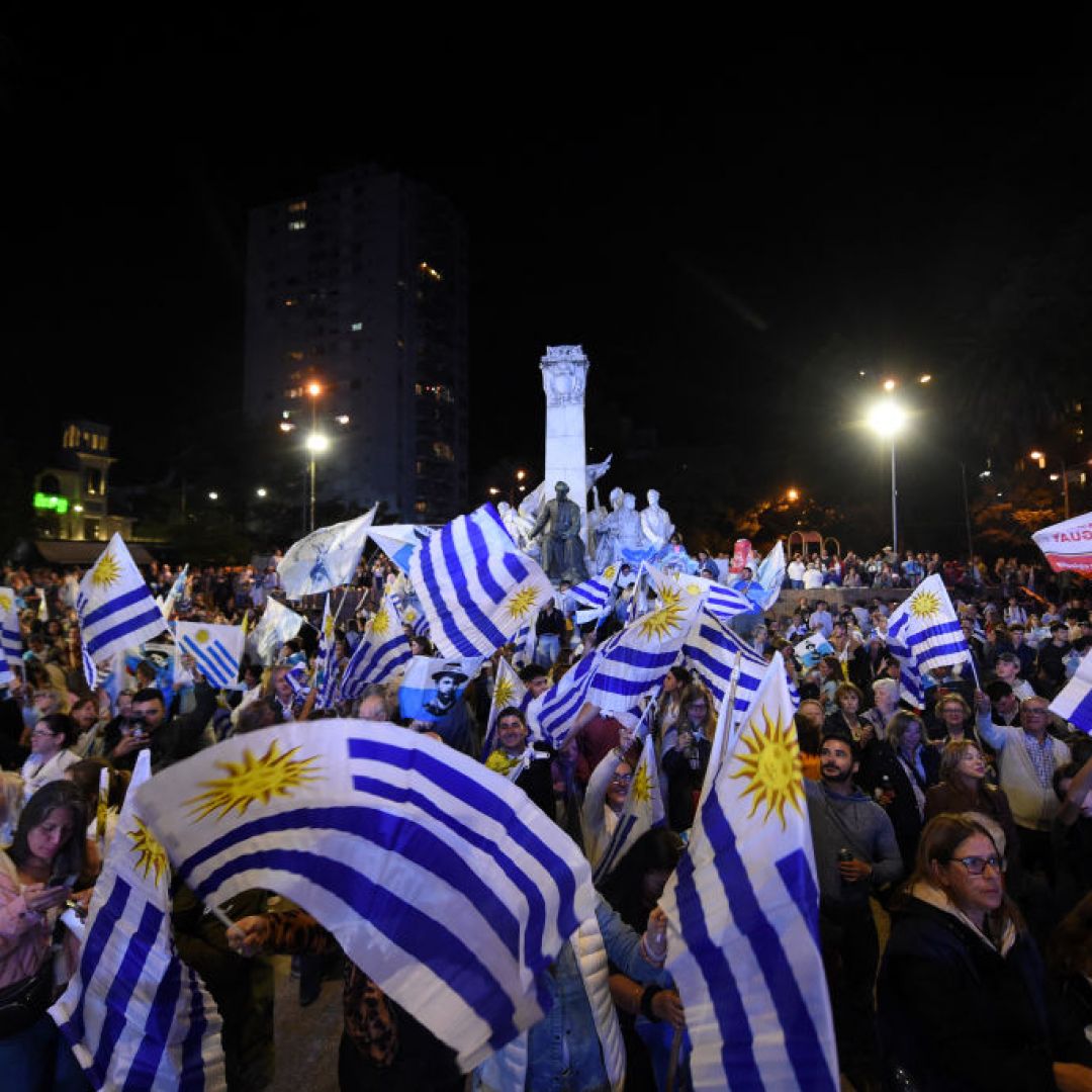 People wave Uruguayan flags after the first results of the presidential and legislative elections were announced, at Plaza Varela Square in Montevideo on Oct. 27, 2024. 