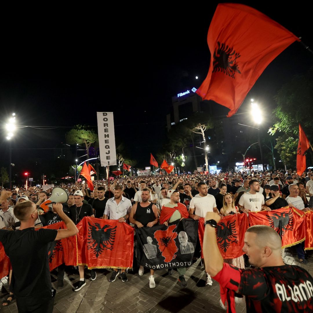 Protestors hold national flags as they gather outside Albania's prime minister's office to oppose the construction of luxury resorts, in Tirana on June 25.Protestors hold national flags as they gather outside Albania's prime minister's office to oppose the construction of luxury resorts, in Tirana on June 25.