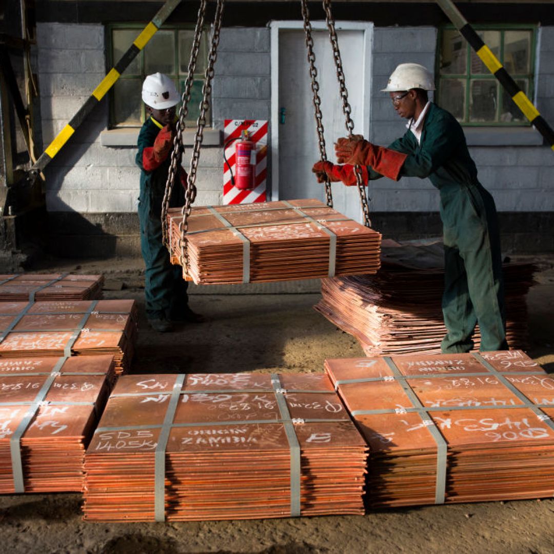 Workers move batches of copper sheets on July 6, 2016, in Mufulira, Zambia.