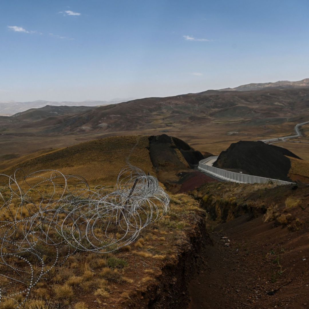 A picture taken on Aug. 16, 2021, shows the landscape of Iran behind a section of the newly completed wall on Turkey’s eastern border in Caldiran. 