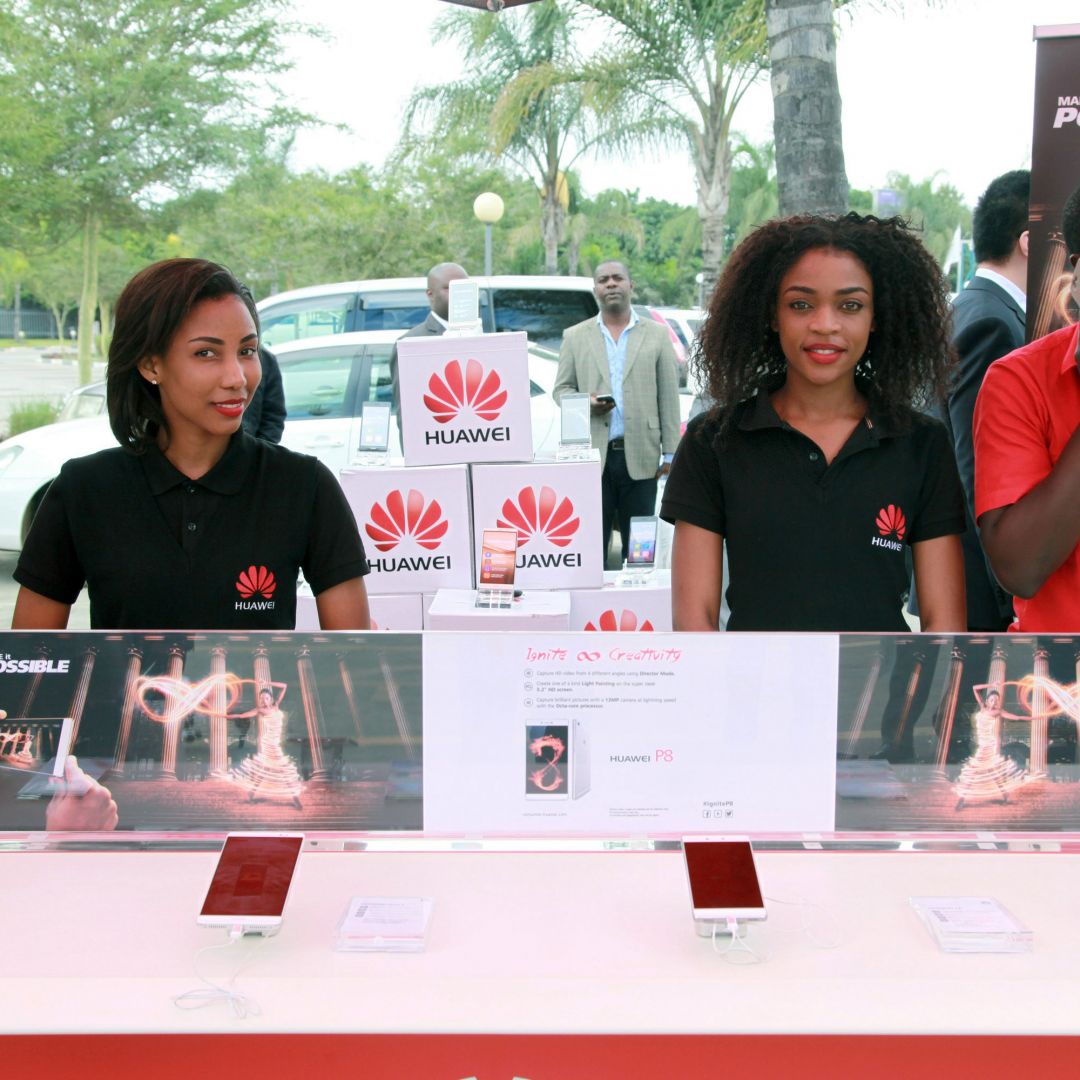 Employees introduce cellphones during a show by Chinese tech firm Huawei in Lusaka, Zambia, during April 2016.