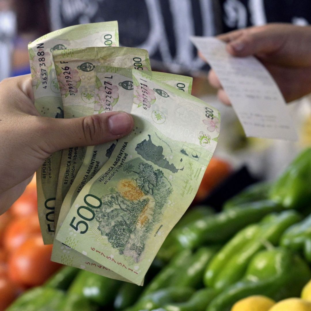 A woman pays for fruits and vegetables in Argentine pesos at a market in Buenos Aires on Feb. 10, 2023. A woman pays for fruits and vegetables in Argentine pesos at a market in Buenos Aires on Feb. 10, 2023.