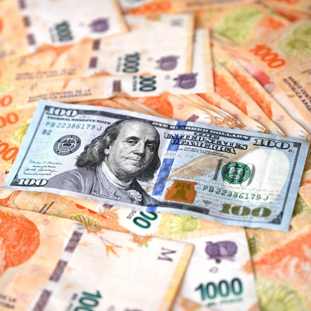 This illustration shows a $100 banknote on top of Argentine pesos in Buenos Aires, Argentina, on Oct. 10, 2023. This illustration shows a $100 banknote on top of Argentine pesos in Buenos Aires, Argentina, on Oct. 10, 2023.