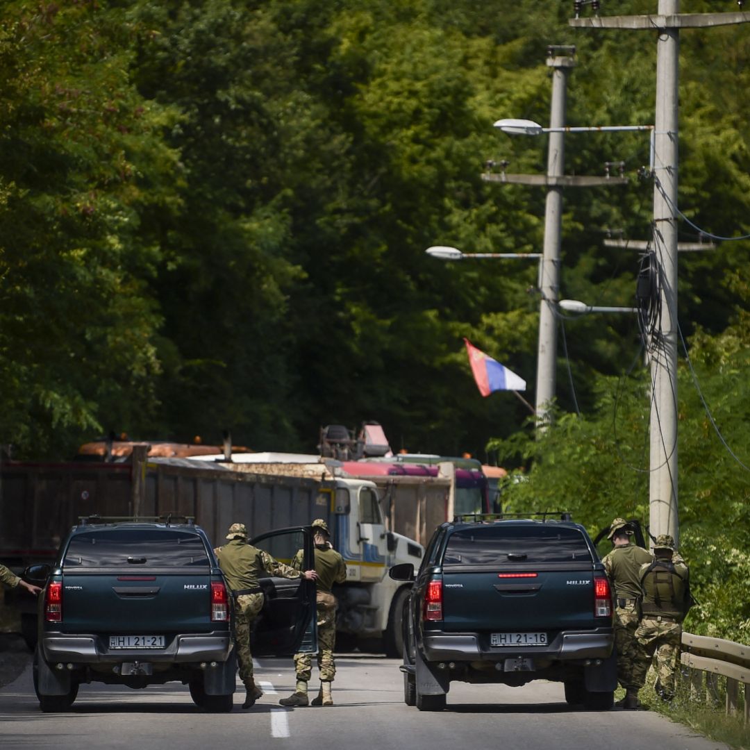 NATO soldiers patrol a roadblock set up by ethnic Serbs near Zubin Potok, a town in northern Kosovo, on Aug. 1, 2022. 