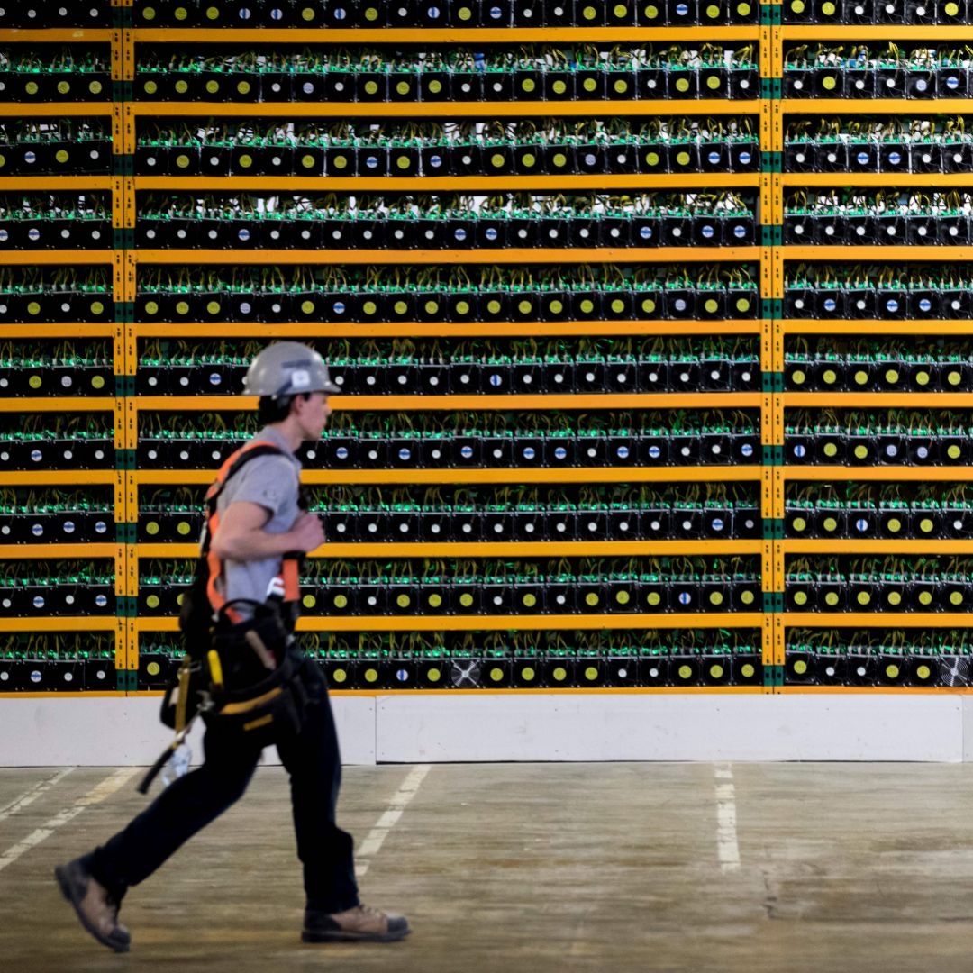 A worker passes a bitcoin mining operation in Quebec in March 2018.